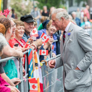 King Charles II greeting citizens in Ottawa waving Canadian flags.